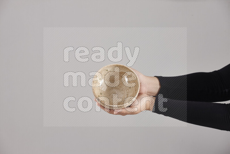 A woman in black abaya holding different pottery essentials in different positions