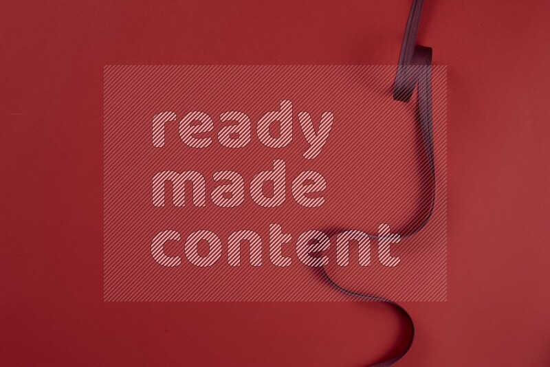 A red collection of sewing and tailoring tools arranged on a red background