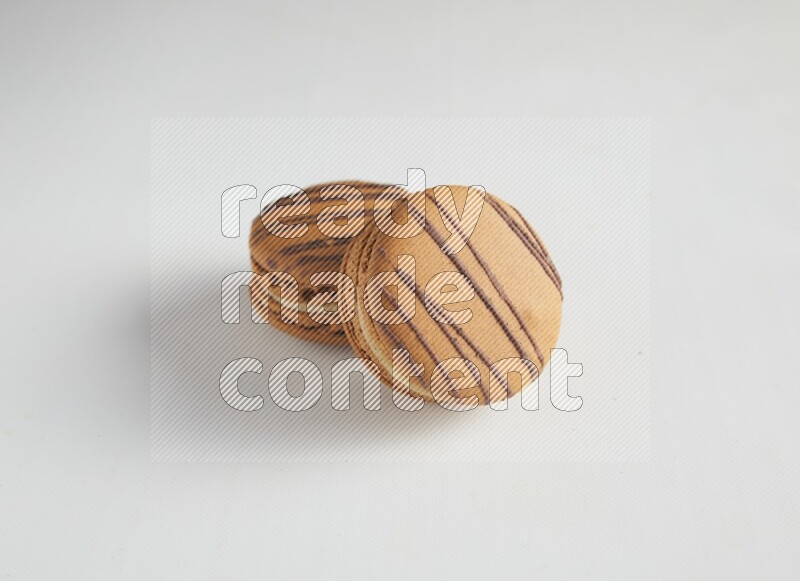 45º Shot of two light brown  Almond Cream macarons on white background