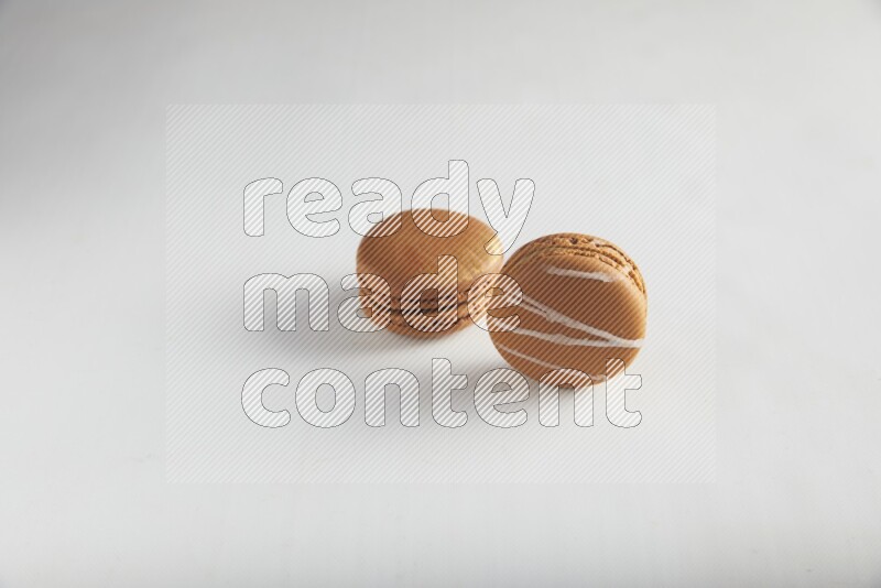 45º Shot of of two assorted Brown Irish Cream, and Brown Coffee macarons  on white background