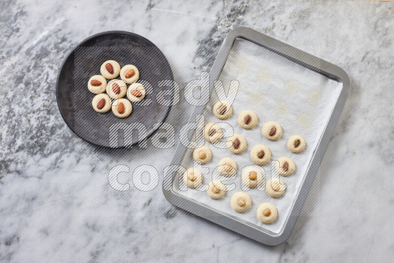 Ghoriba step by step with its ingredient, flour, powdered sugar, ghee and nuts on grey marble background