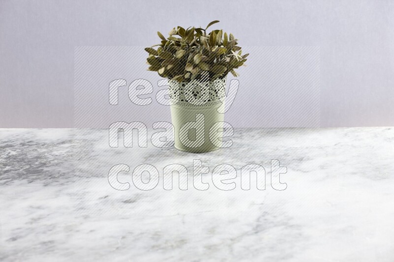 Artificial plant in green decorative pot on grey marble background