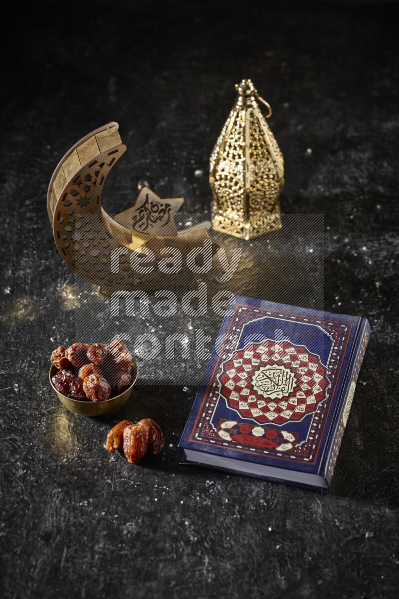 Dates in a metal bowl with quran beside golden lanterns in a dark setup