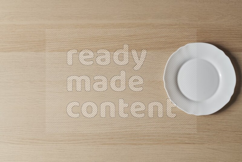 A white ceramic circular plate on light wooden background