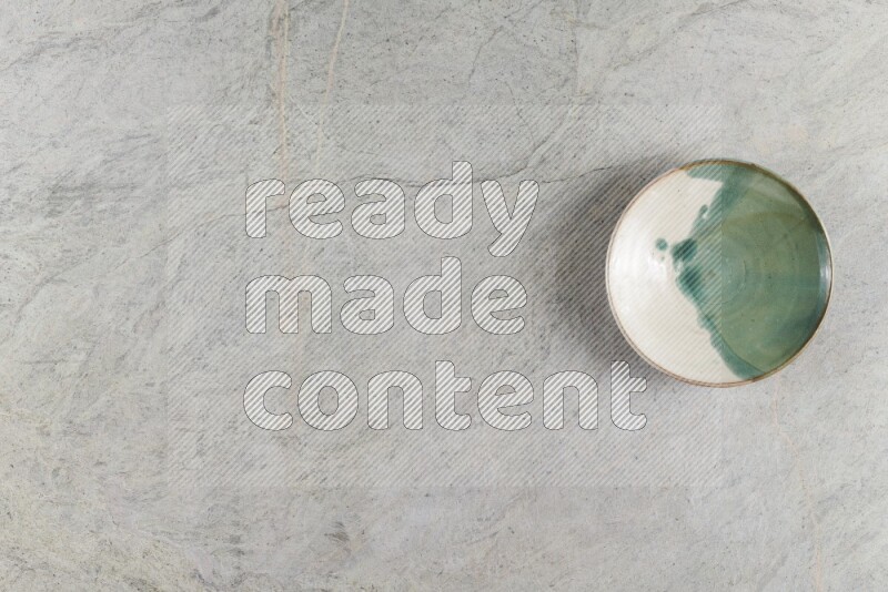 A multicolored pottery Bowl on grey marble background