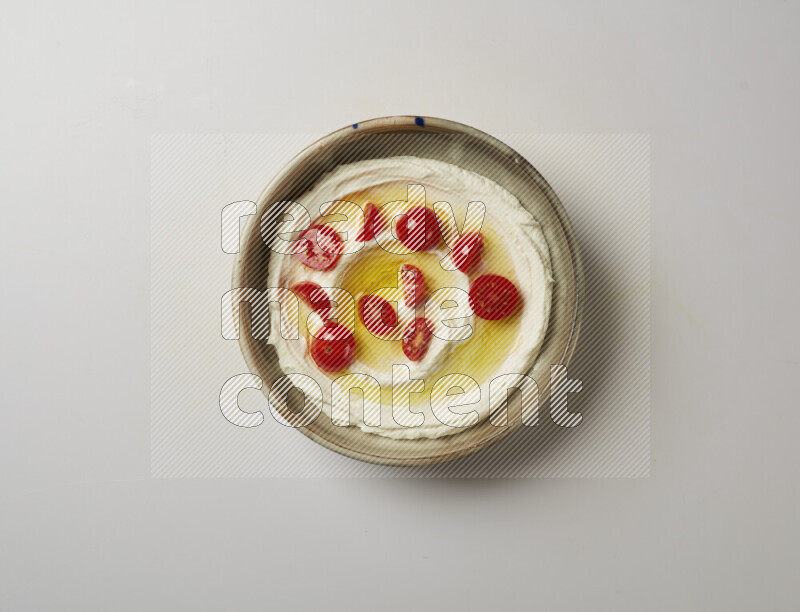 Lebnah garnished with cherry tomato in a grey pottery plate on a white background