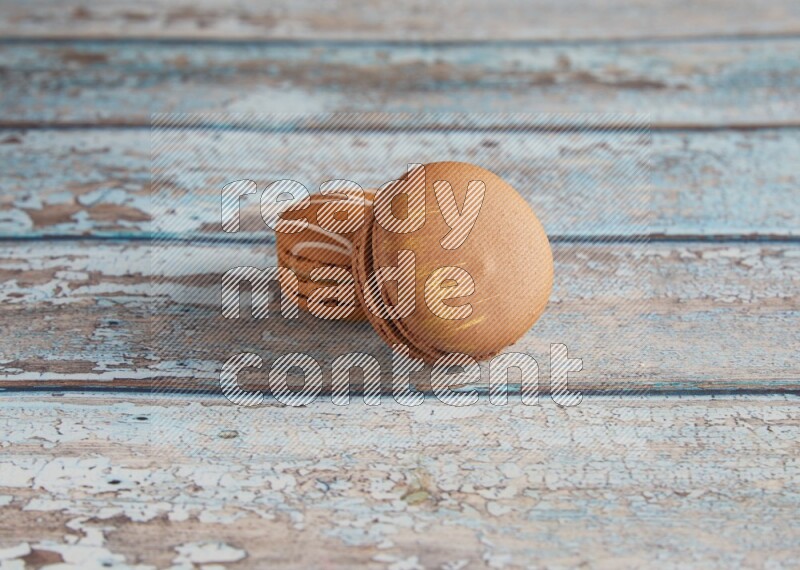 45º Shot of of two assorted Brown Irish Cream, and Brown Coffee macarons on light blue background