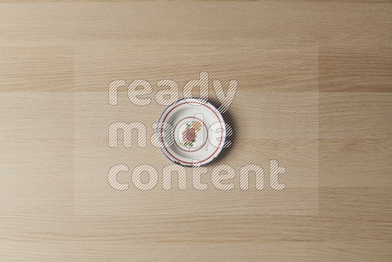 صحن معدني عتيق على خلفية خشبية فاتحة