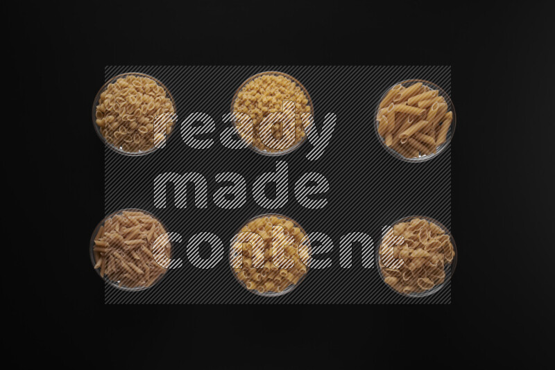 أنواع مختلفة من المعكرونة في أوعية زجاجية علي خلفية سوداء