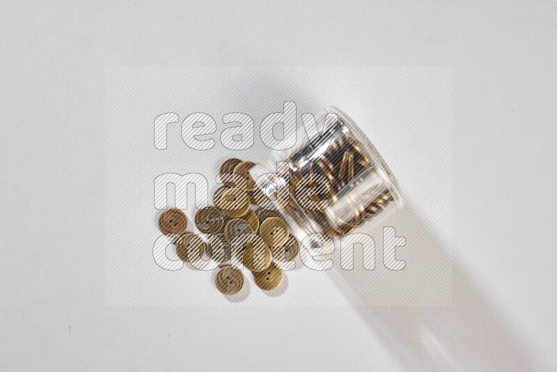 Colored buttons in a glass jar on grey background