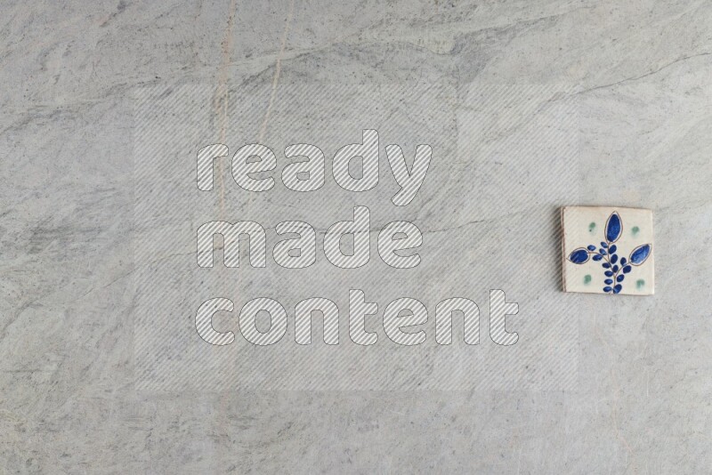 A decorative pottery coaster on grey marble background