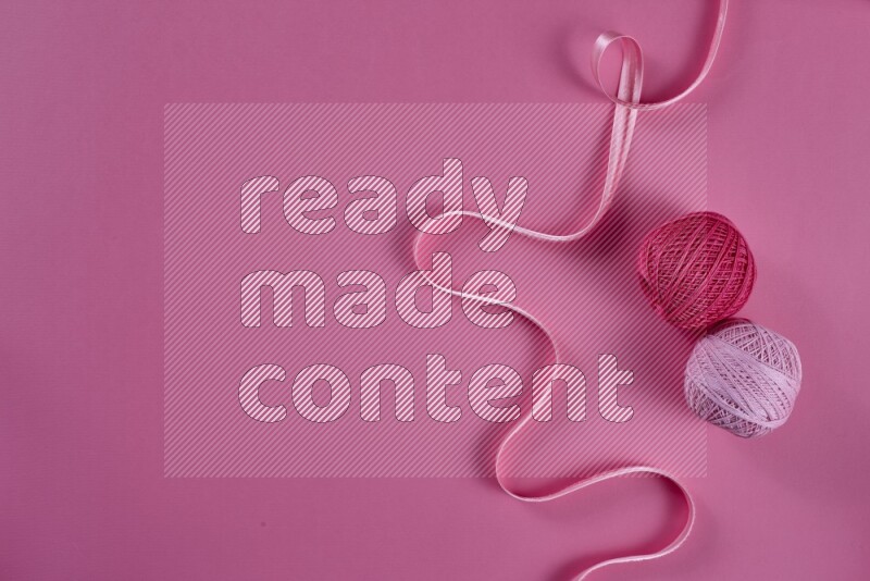 A pink collection of sewing and tailoring tools arranged on a pink background