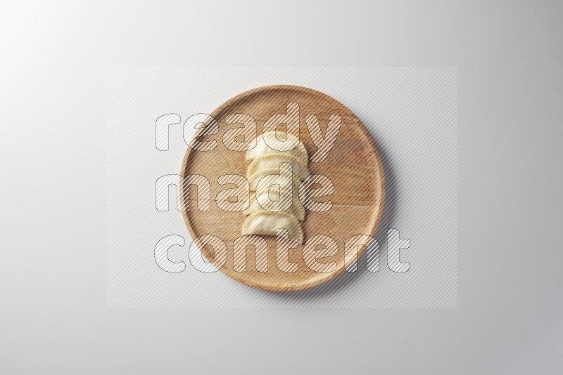 Five Sambosas on a wooden round plate on a white background