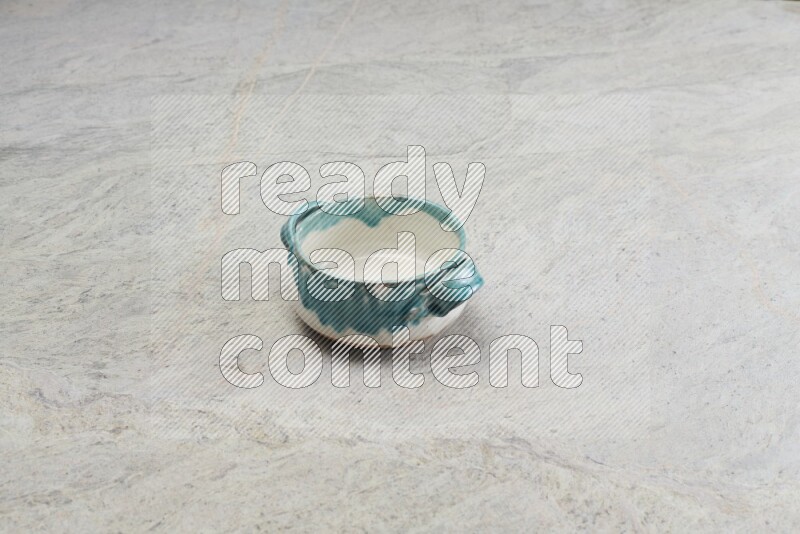 A multicolored pottery bowl on grey marble background