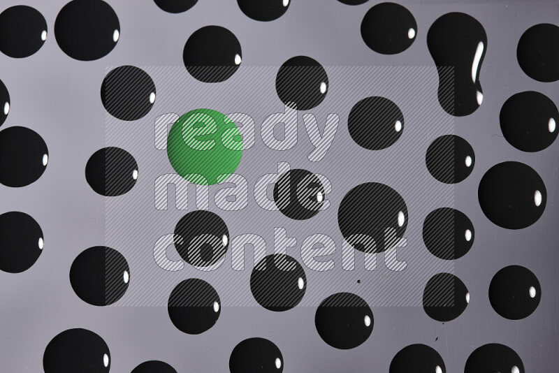 Close-ups of abstract green and black paint droplets on the surface