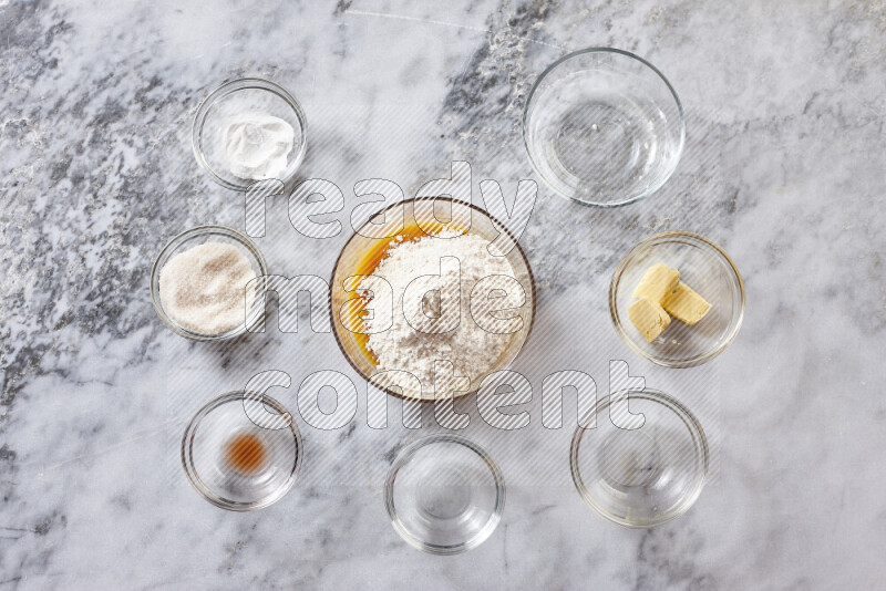 Cookies step by step with its ingredient, flour, butter, brown sugar, egg, vanilla extract, white sugar, chocolate chips and baking soda on grey marble background
