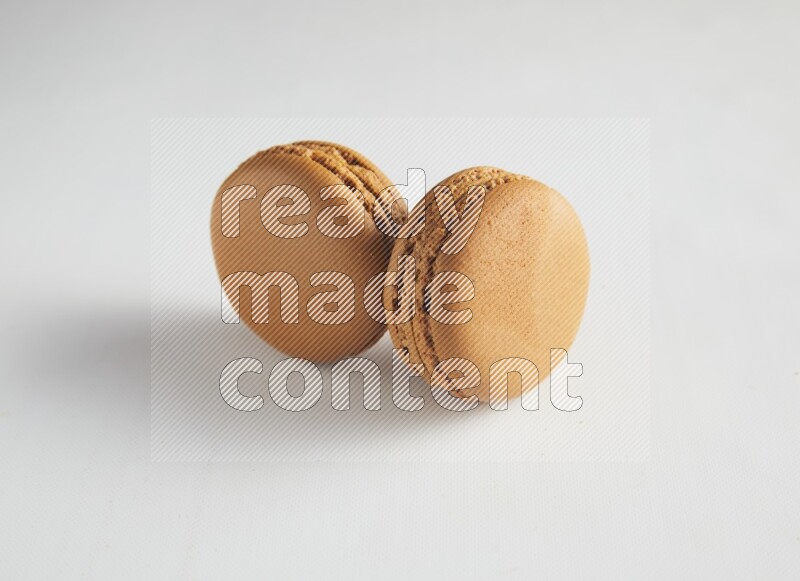 45º Shot of two Brown Maple Taffy macarons on white background