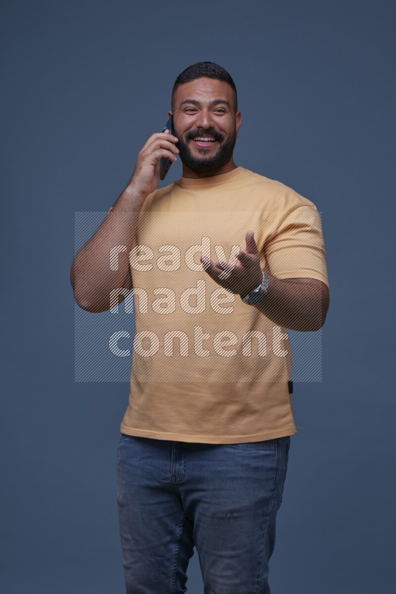 A man Calling on Blue Background wearing Orange T-shirt