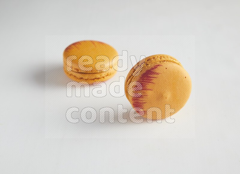 45º Shot of two orange Exotic macarons on white background