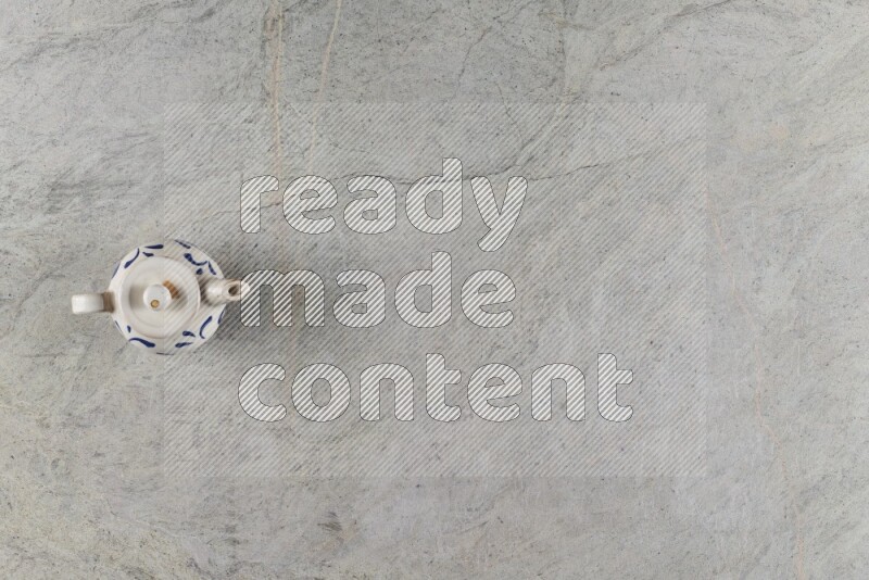 A pottery teapot on grey marble background
