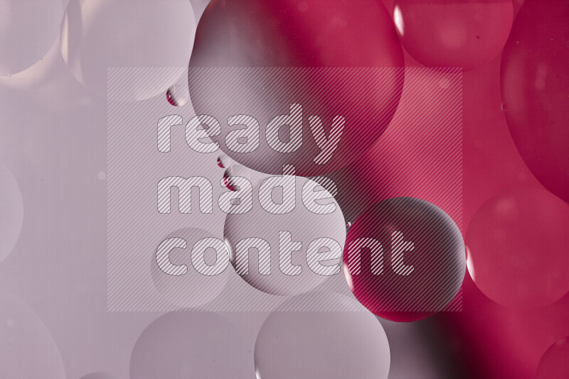 لقطات مقربة لفقاعات من الزيت على سطح الماء باللون الأبيض والوردي