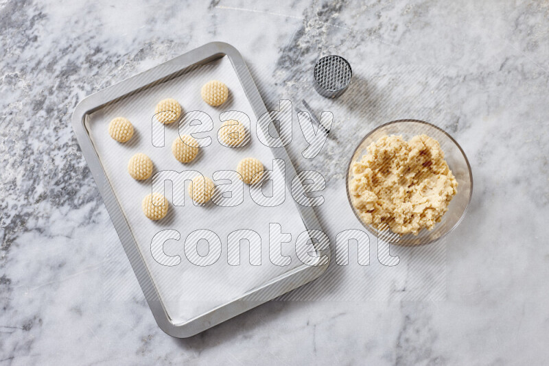 Kahk step by step with its ingredients ghee, sugar, flour, sesame, yeast, water and kahk flavor on grey marble background