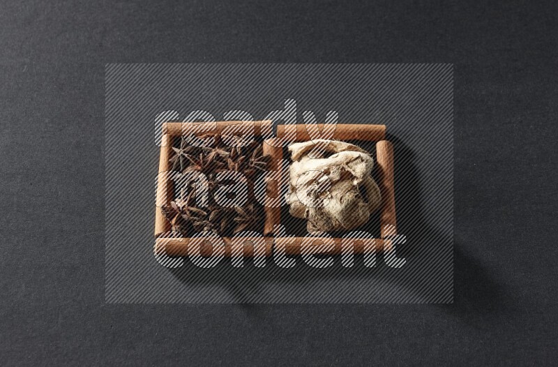 2 squares of cinnamon sticks full of star anise and dried ginger on black flooring