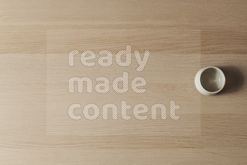 وعاء فخاري أبيض على خلفية خشبية فاتحة