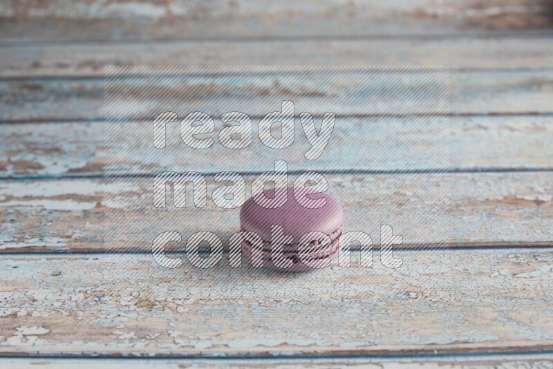 45º Shot of Purple Blueberry macaron on light blue wooden background