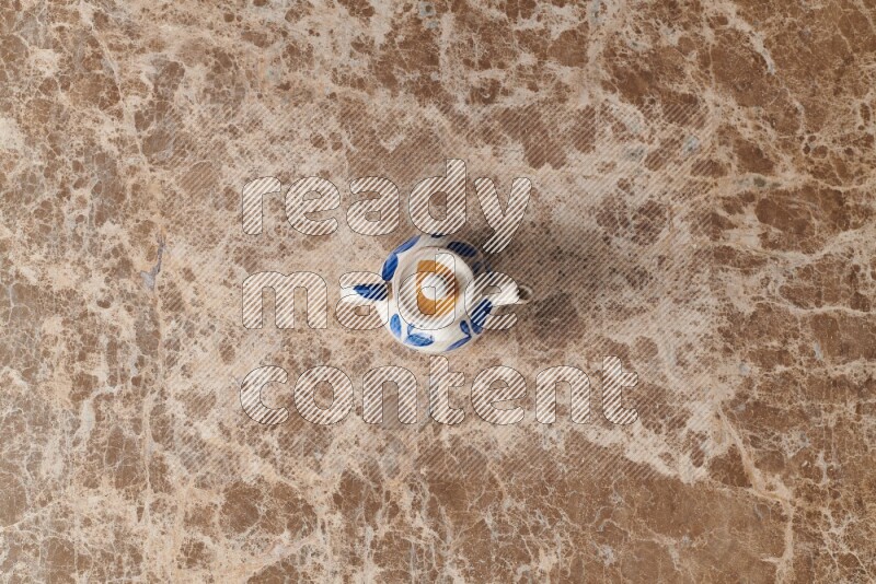 A pottery teapot on beige marble background