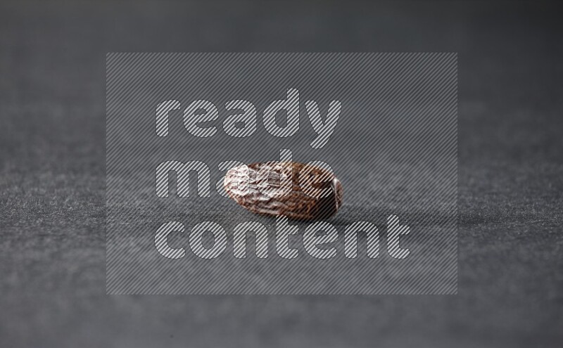 حبة واحدة من البلح المجفف علي خلفية سوداء