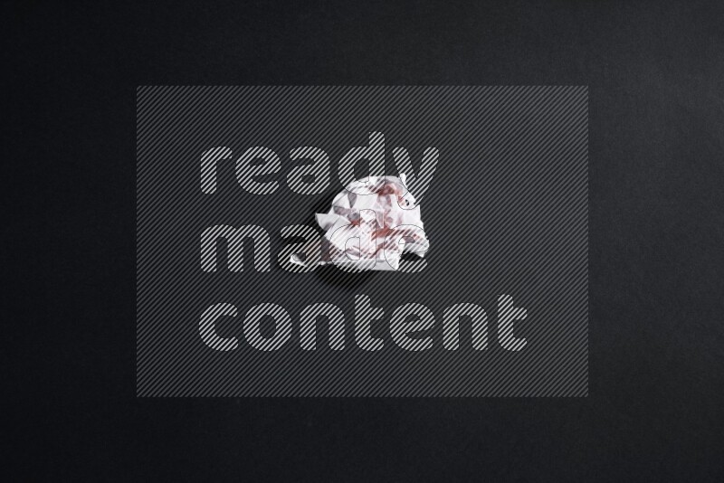 Crumpled notebook sheet on black background