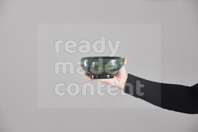 A woman in black abaya holding different pottery essentials in different positions
