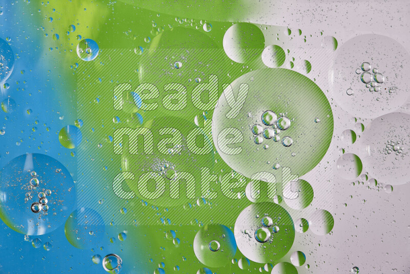 Close-ups of abstract oil bubbles on water surface in shades of white, green and blue