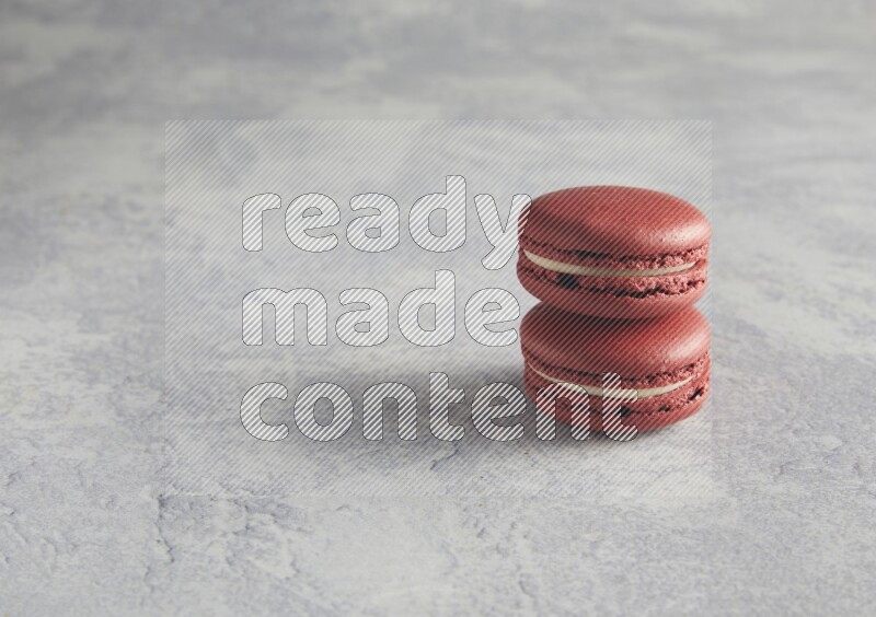 45º Shot of two Red Velvet macarons  on white  marble background