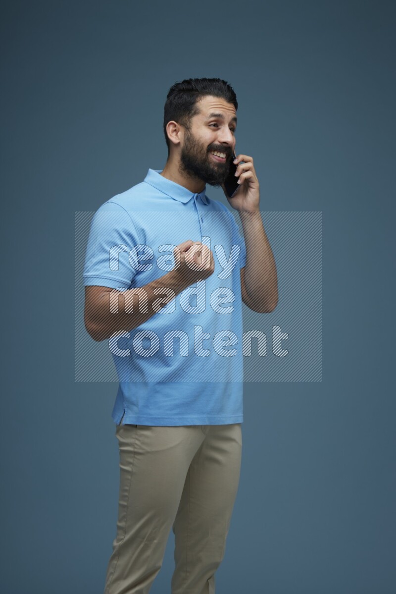 A man having a Call in a blue background wearing a Blue shirt