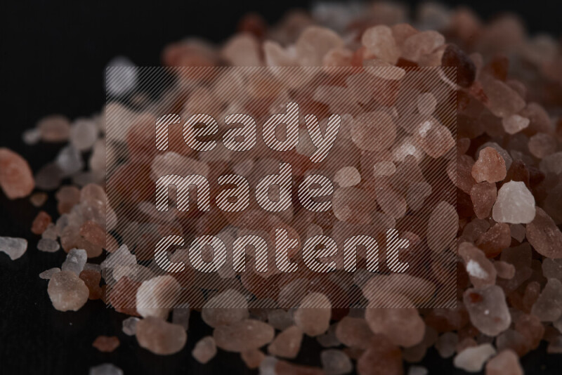 A bunch of coarse himalayan salt crystals on black background