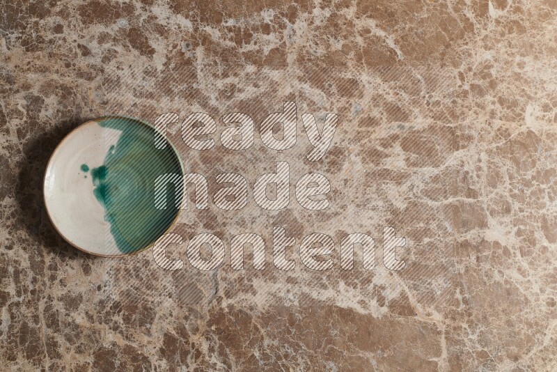 A decorative pottery plate on beige marble background