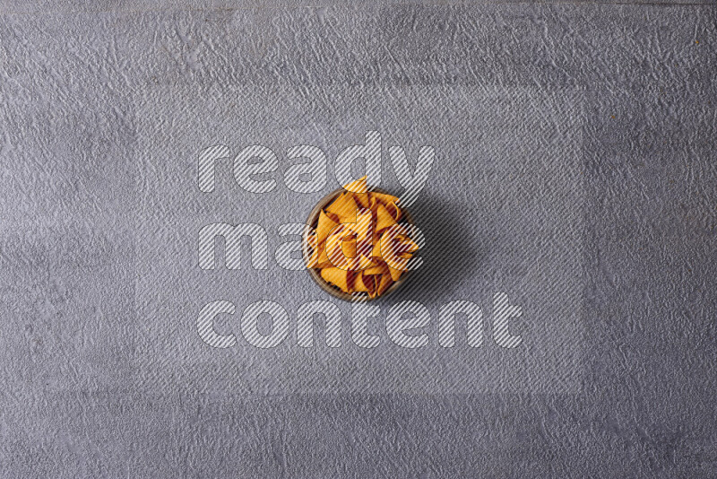 Assorted snacks in pottery bowls on grey background