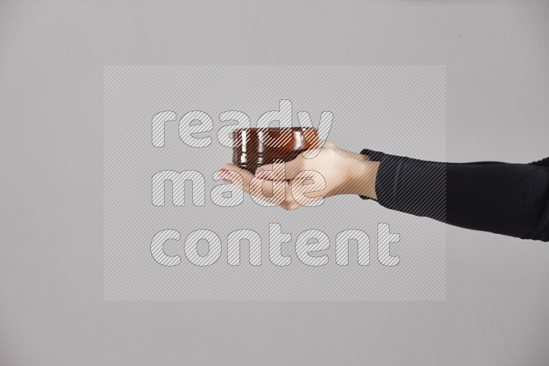A woman in black abaya holding different pottery essentials in different positions