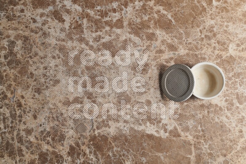 A pottery cup on beige marble background