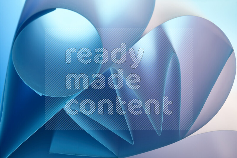 An artistic display of paper folds creating a harmonious blend of geometric shapes, highlighted by soft lighting in blue and white tones