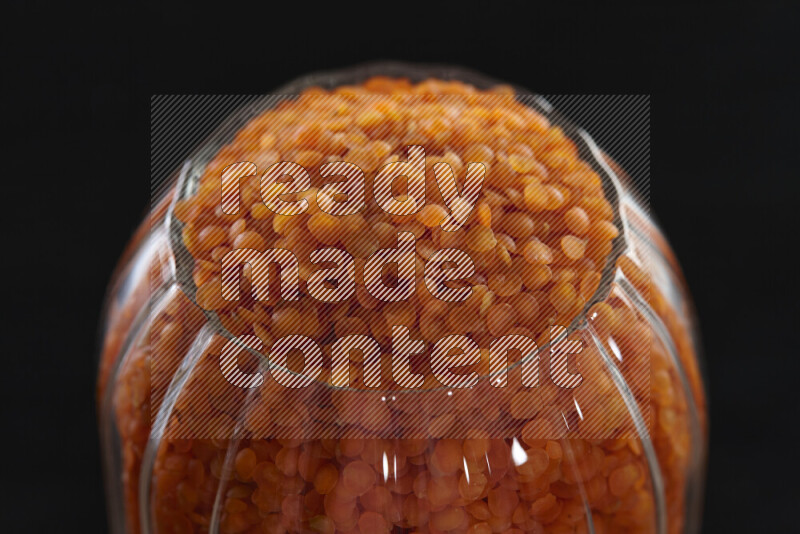 Lentils in a glass jar on black background