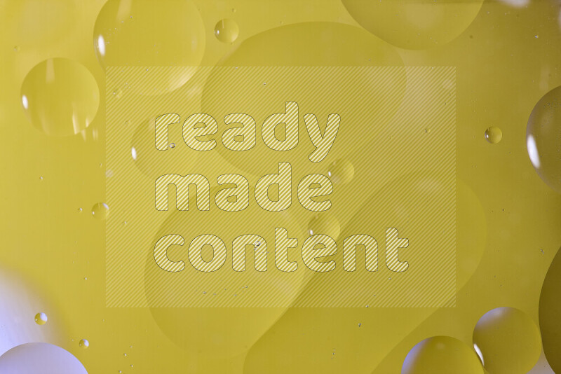 Close-ups of abstract oil bubbles on water surface in shades of yellow