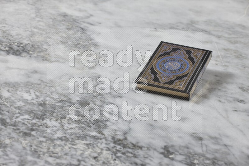Quran with a prayer beads on grey marble background