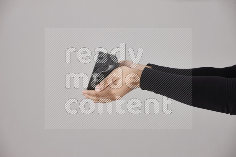A woman in black abaya holding different pottery essentials in different positions