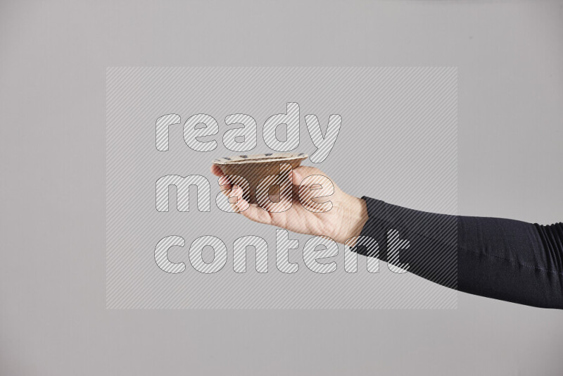 A woman in black abaya holding different pottery essentials in different positions