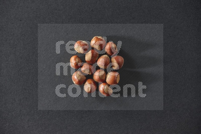 A bunch of hazelnuts on a black background in different angles