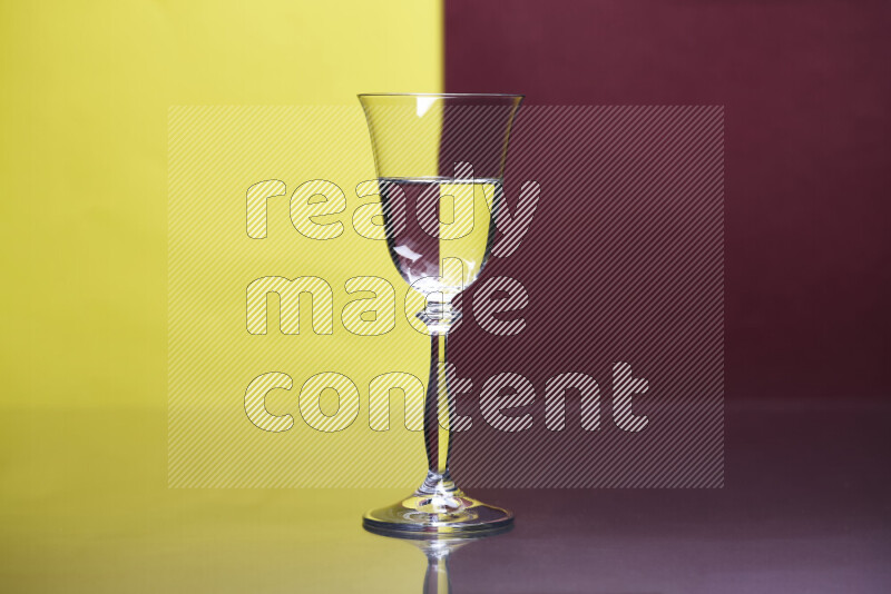 The image features a clear glassware filled with water, set against yellow and dark red background