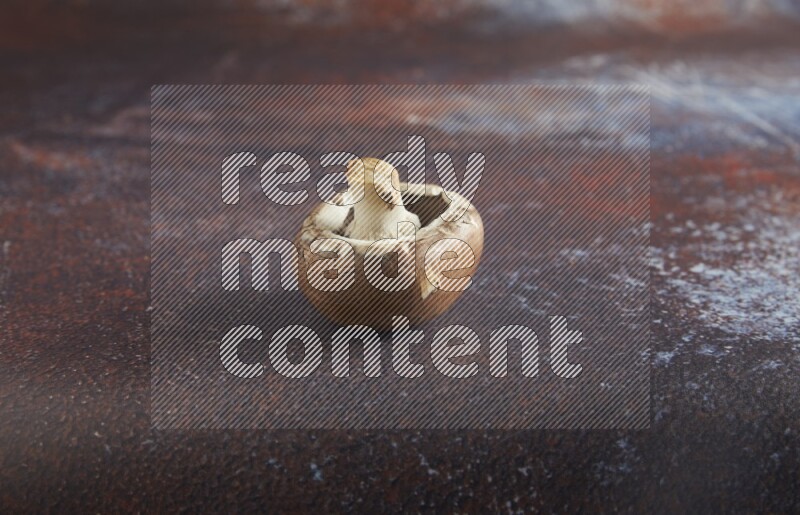 45 degre cremini  mushrooms on a textured reddish rustic metal background